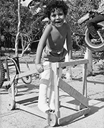 Niño agarrándose de una andadera con las barras inclinadas.