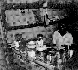 Child behind counter with many jars of things.