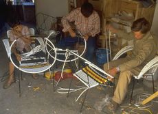 people weaving with plastic ribbons