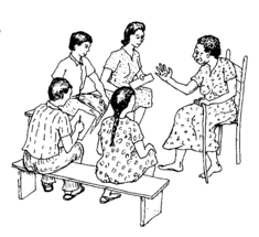 A small group of men and women sit together, talk and write.