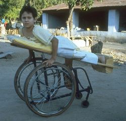 demuestra foto dean niño sobre una silla de ruedas con camilla.