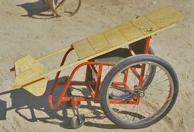 Photo of wheelchair with wooden lying board on top.