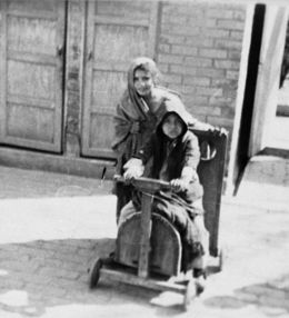 una mujer empujando a una niño en una silla de ruedas.
