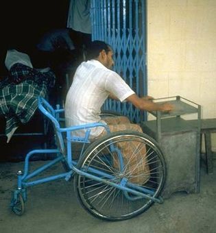 Hombre en silla de ruedas construyendo muebles.